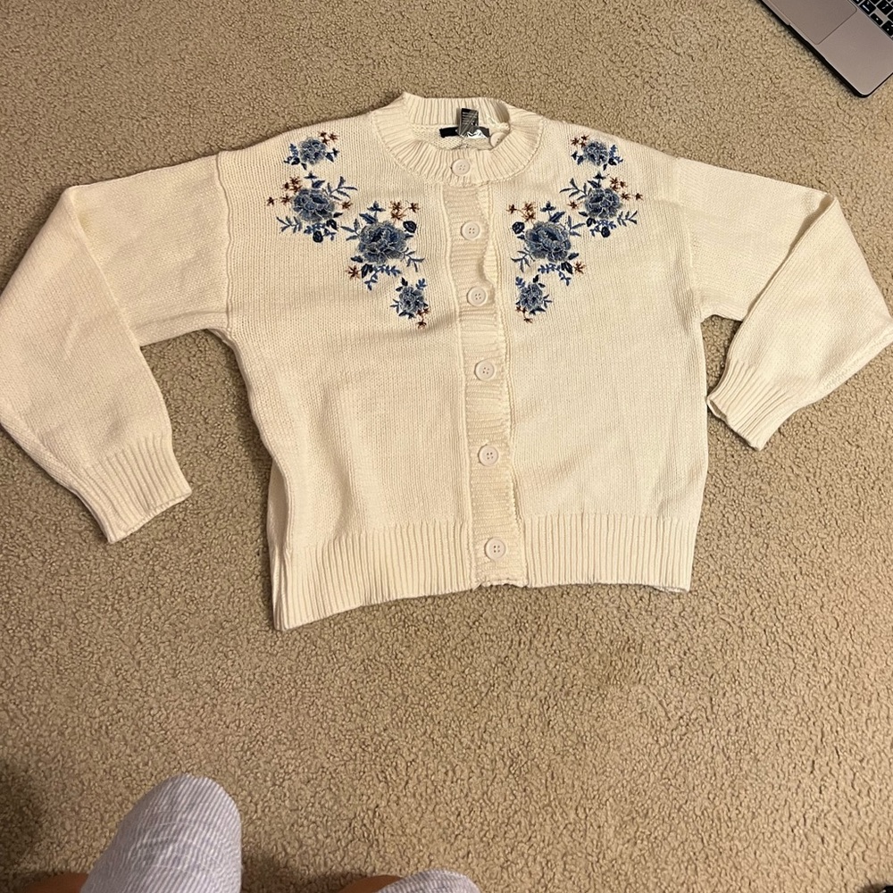 White knit sweater with blue embroidered flowers